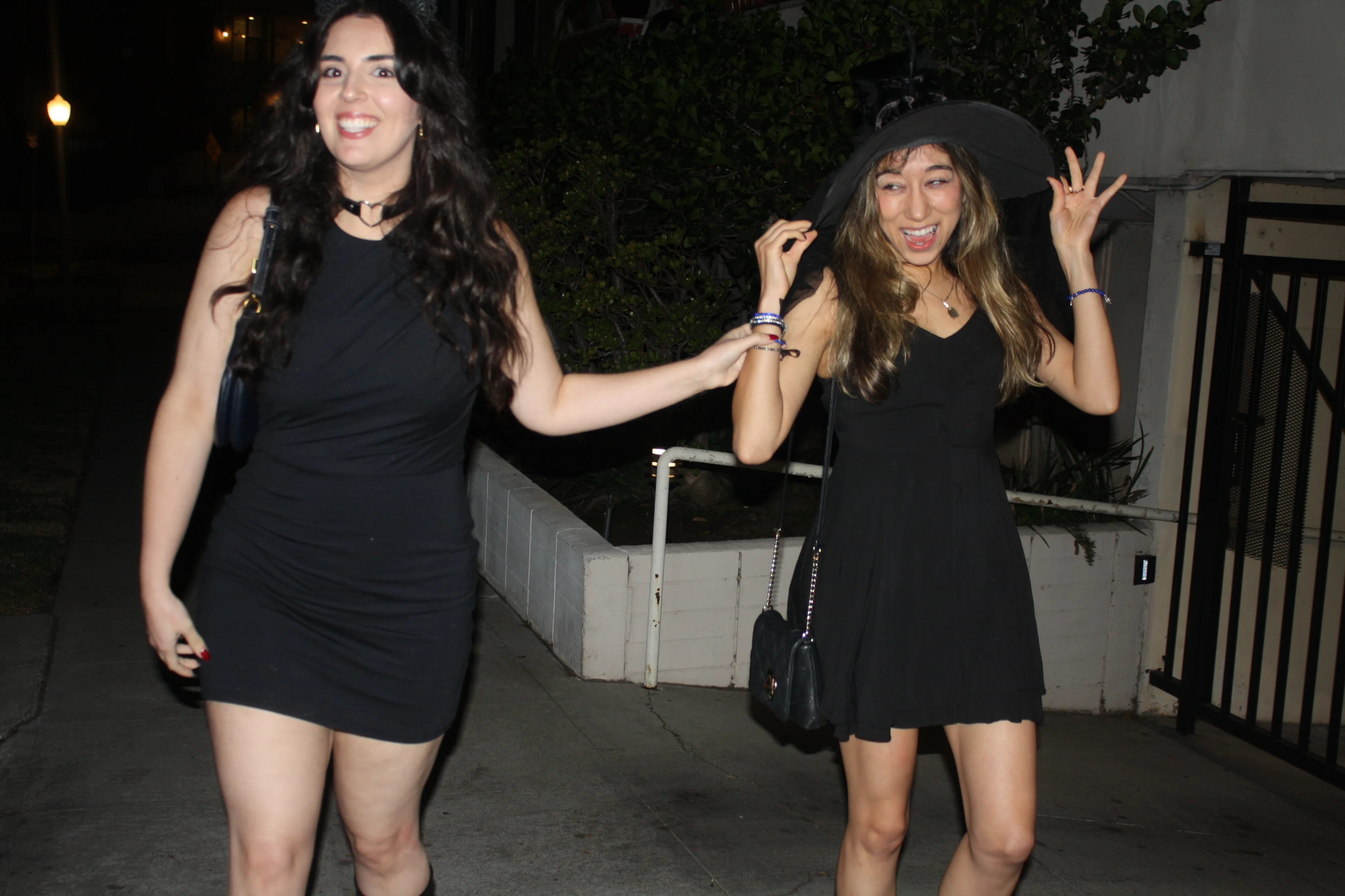 Two friends dressed as witches laughing together at Halloween 2024
